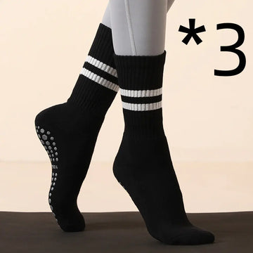 Black non-slip yoga and Pilates socks with white stripes for enhanced grip and performance during workouts.