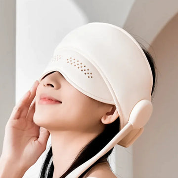 Woman using a relaxing head and eye massager for soothing tension and promoting relaxation.