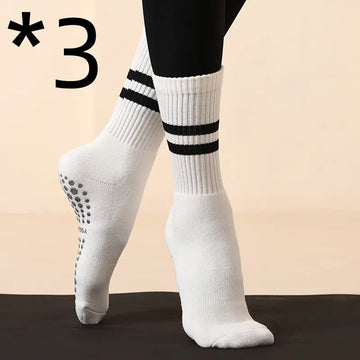 Non-slip white yoga Pilates socks with black stripes, designed for grip and comfort during workouts.